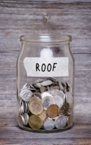 roof, money jar with coins on wood table