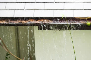 Close up view on clogged Rain Gutter in the rain Home Guttering Gutters1-min