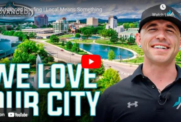 Smiling roofing team member with we love our city text