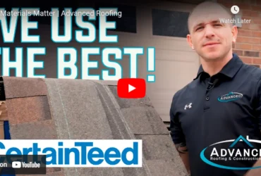 Man stands next to roof shingle board with "We use the best" text