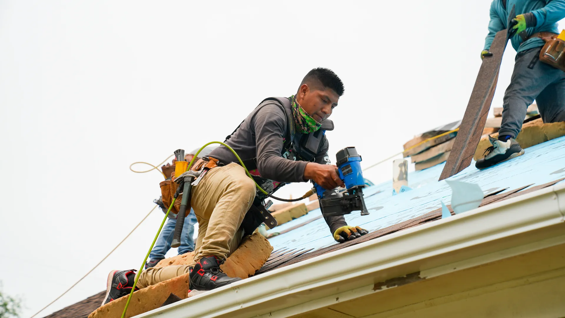 Advanced Roofing installer fastening asphalt shingles on a North Alabama roof